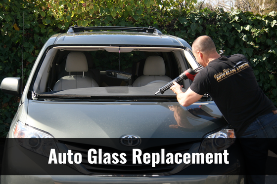 A man is installing a new windshield on a car.