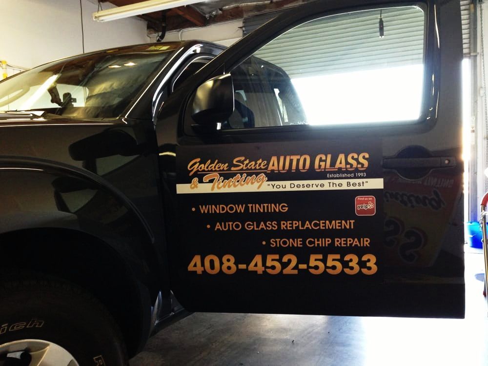 A black truck with a sign that says golden state auto glass