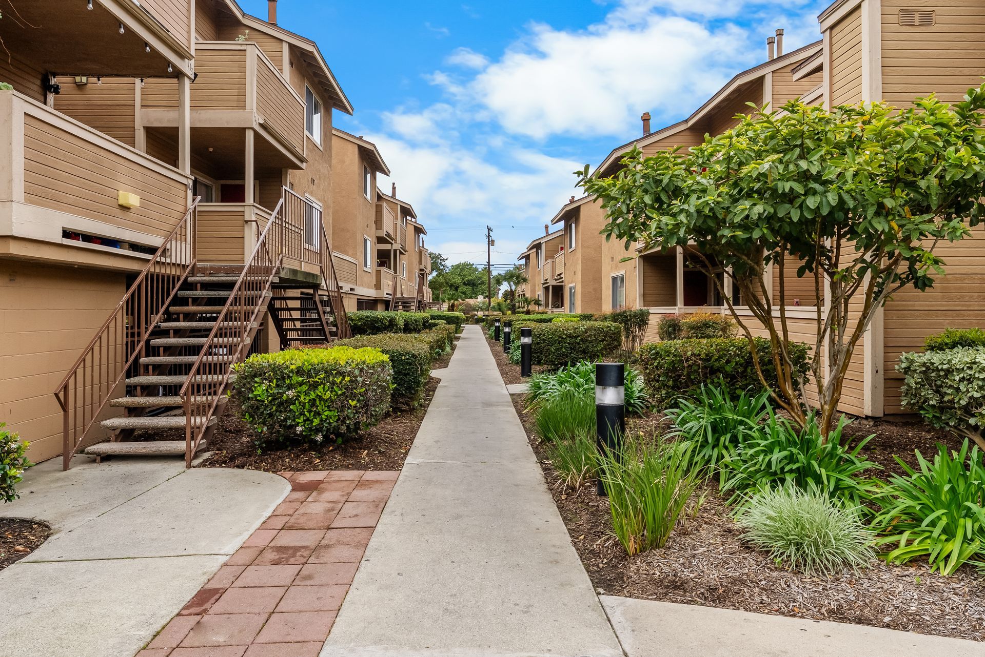 Paved walkway through the exterior of double story apartments