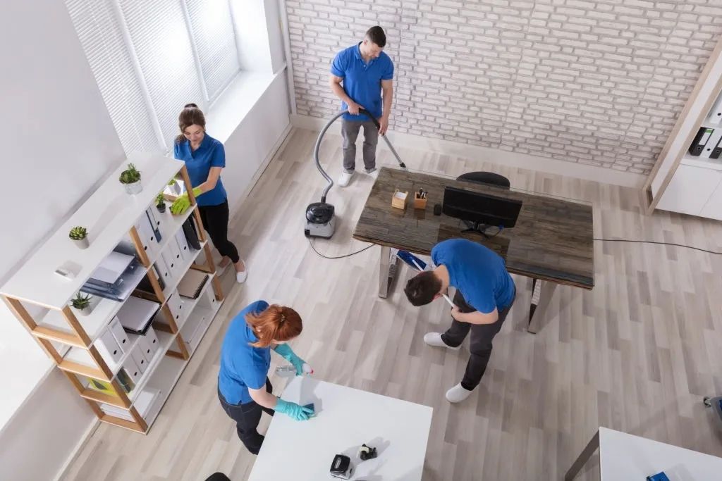 Aerial view of 4 office cleaners cleaning a modern office