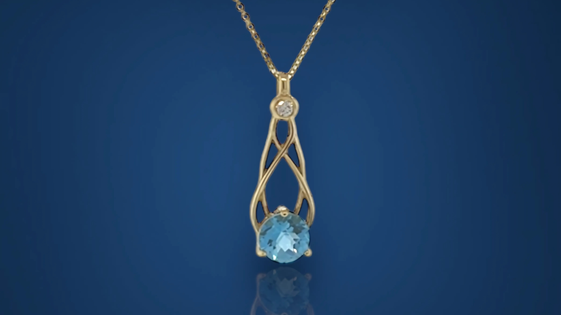 A gold necklace with a blue stone and a diamond