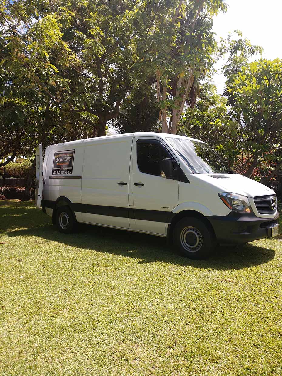White car parked on a grassy field — Makawao, HI — Hawaiian Door & Window Screens