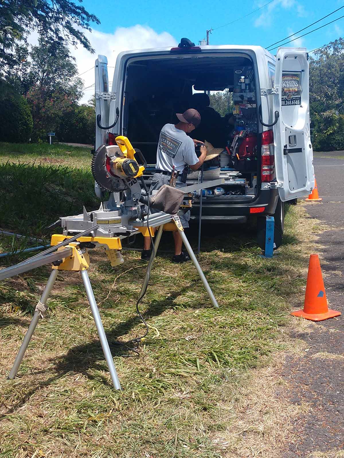 Man working with tools at the back of the car — Makawao, HI — Hawaiian Door & Window Screens