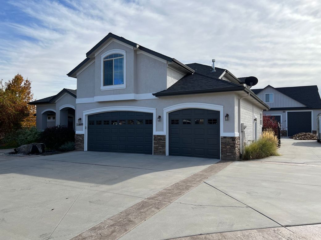 A large house with two garage doors and a driveway