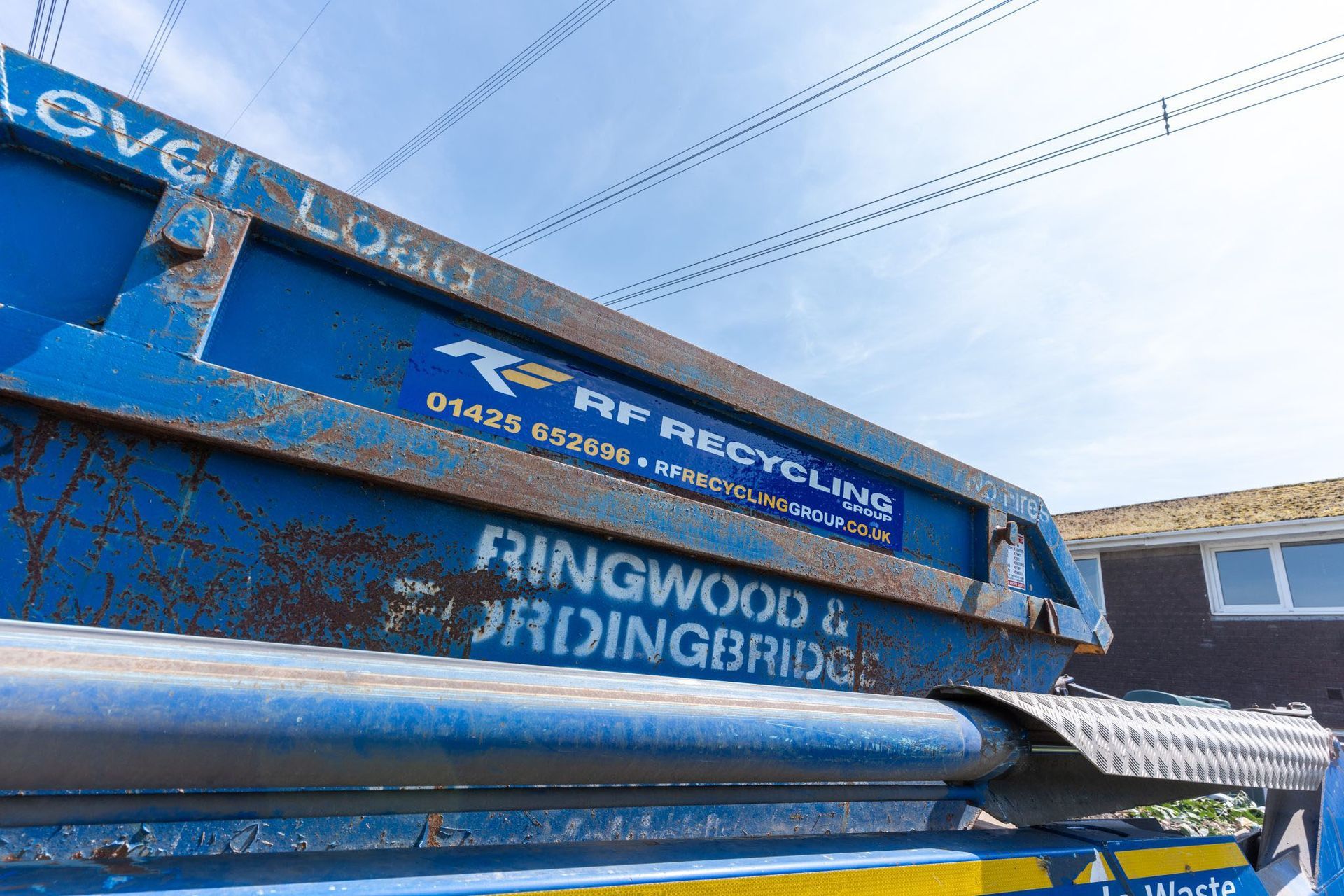 rf recycling close up of skip showing the level load text