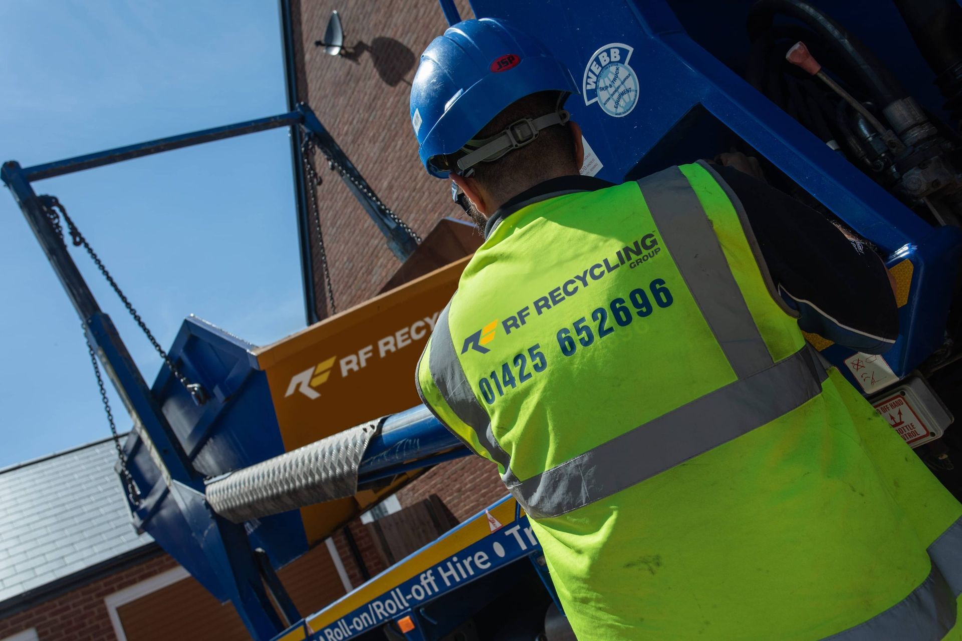 rf recycling man operating lorry to unload the skip