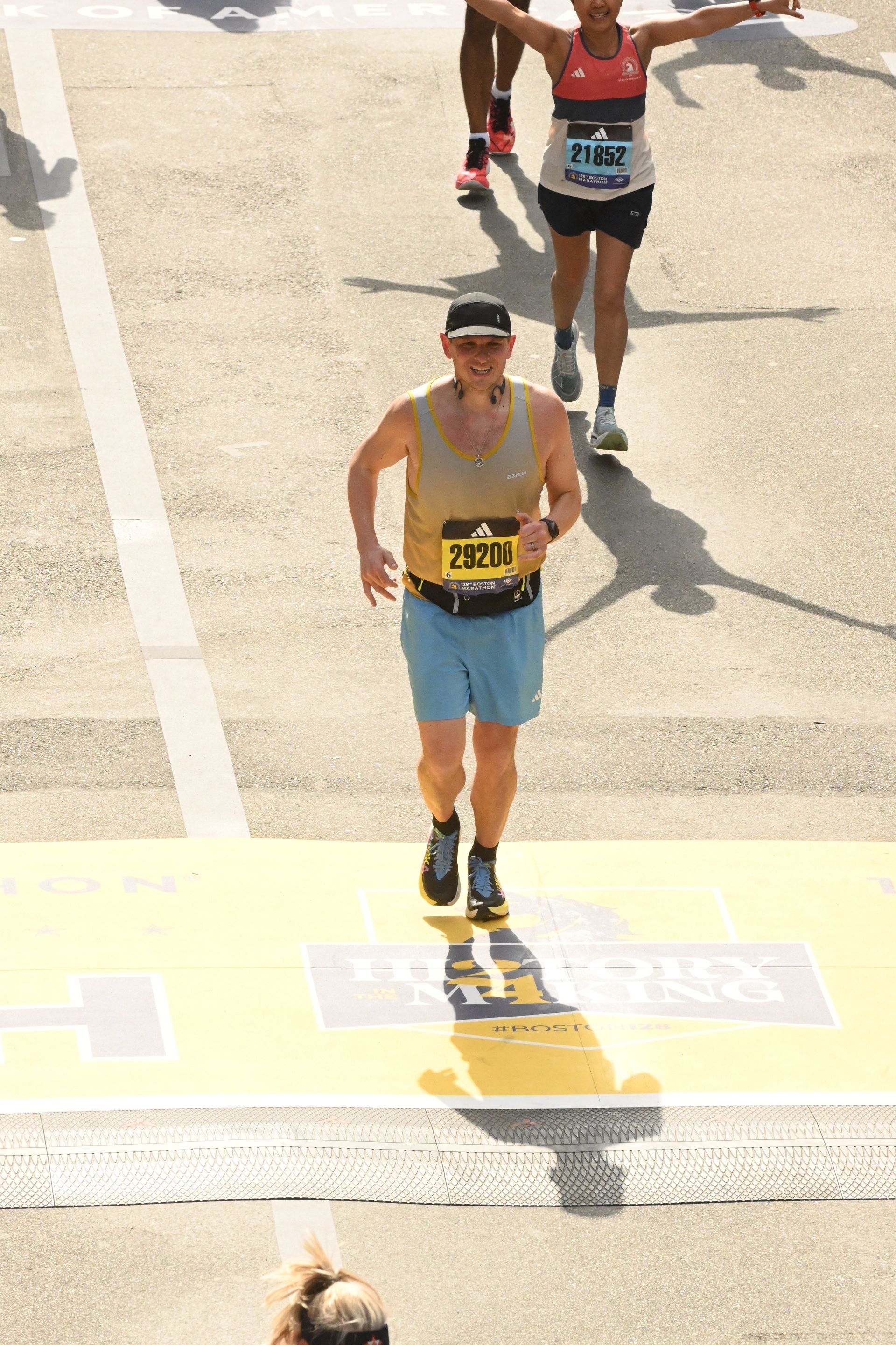 A man and a woman are crossing the finish line of a marathon