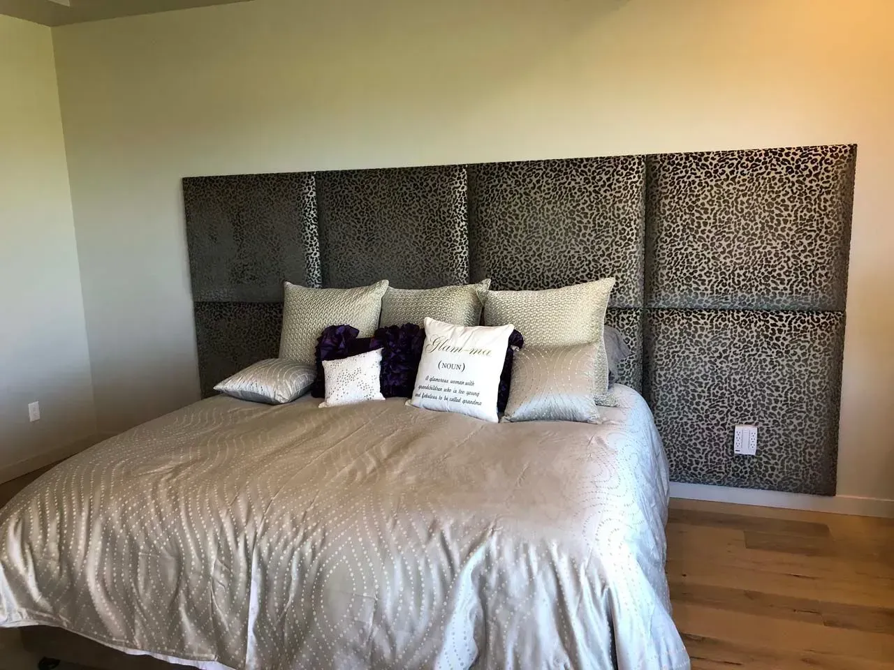 A bed with a headboard and pillows in a bedroom.