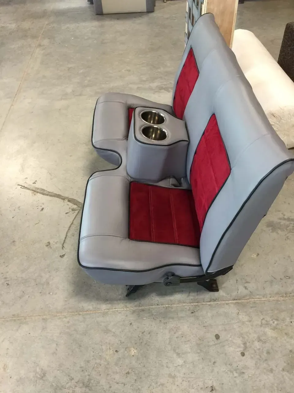 A grey and red car seat with two cup holders