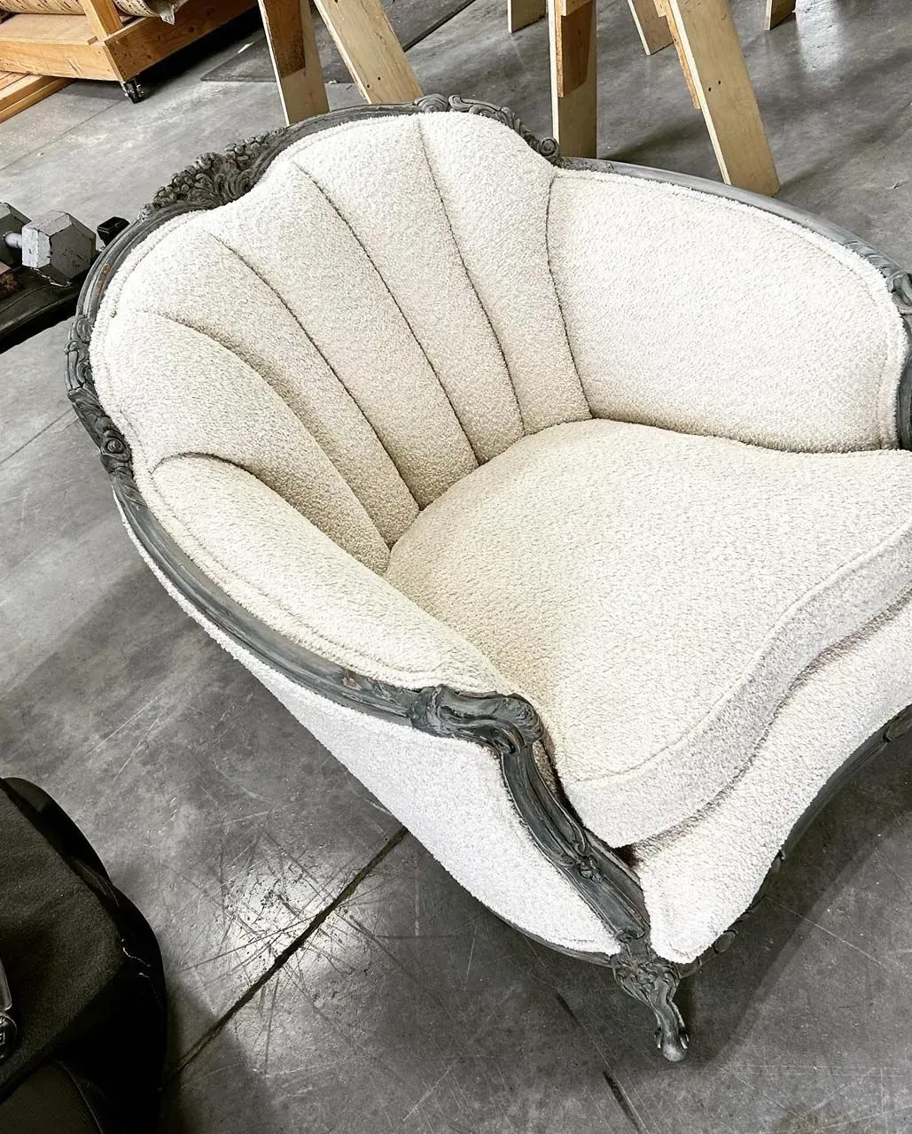 A white chair is sitting on a concrete floor.