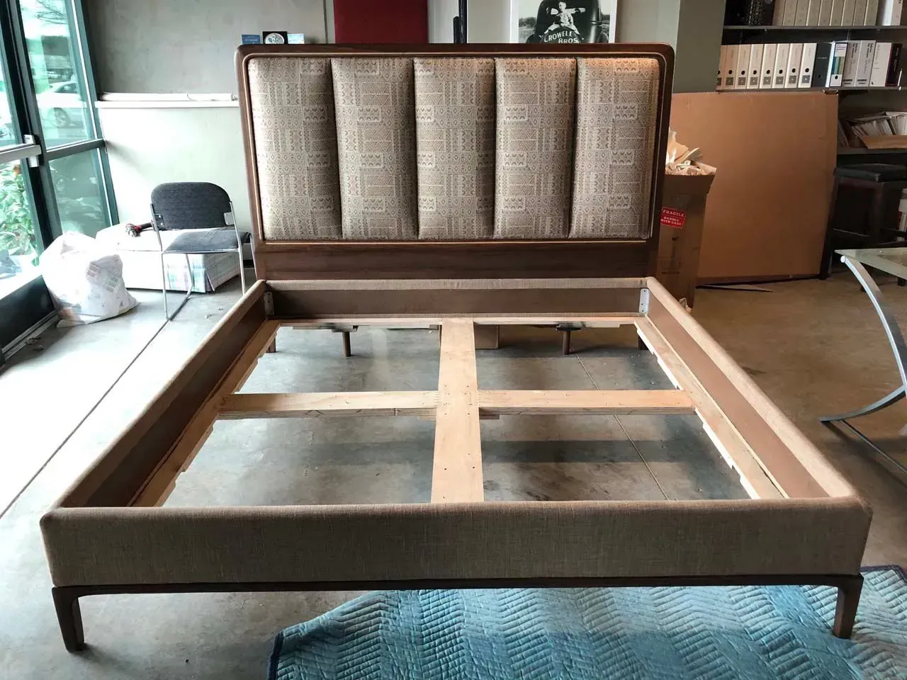 A bed frame is sitting on the floor in a room