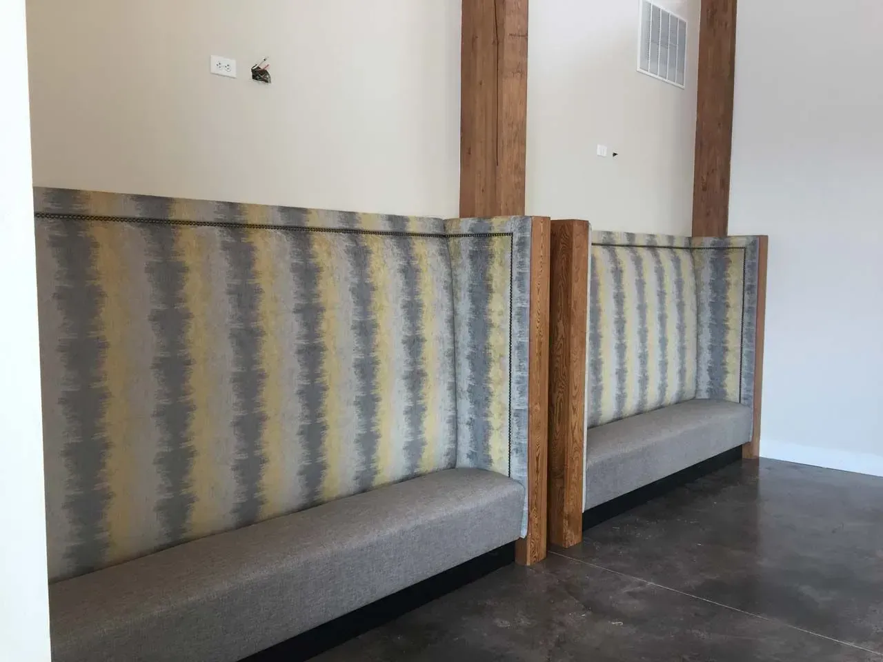A row of benches in a room with a striped fabric on the wall.