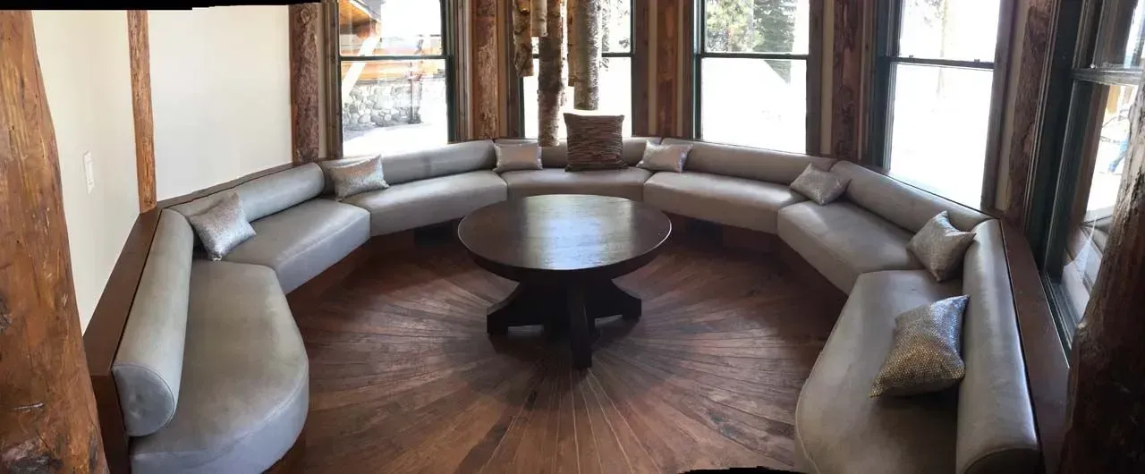 A living room with a round couch and a table.