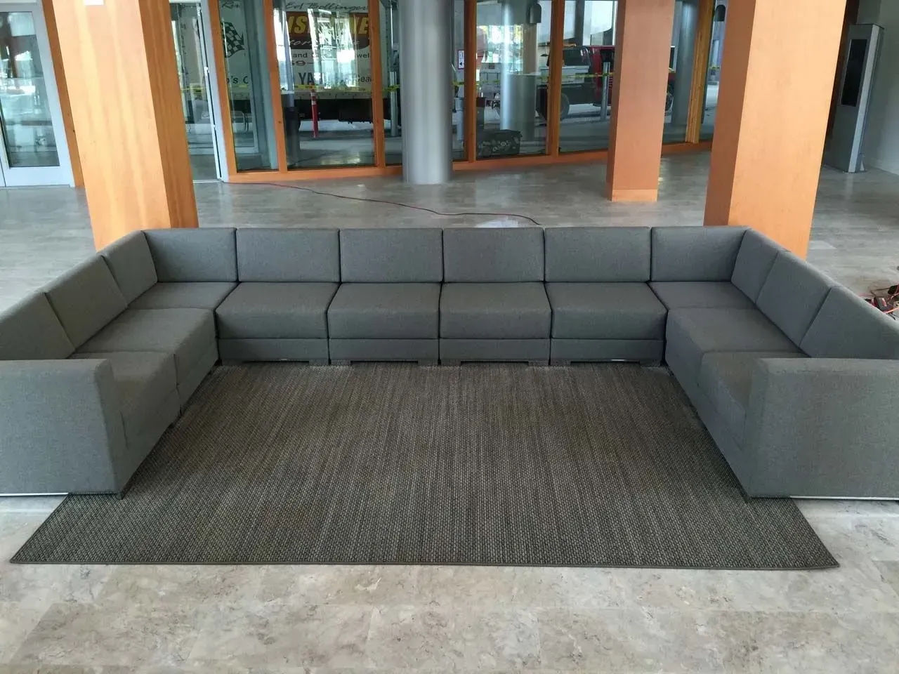 A large sectional couch is sitting on a rug in a room
