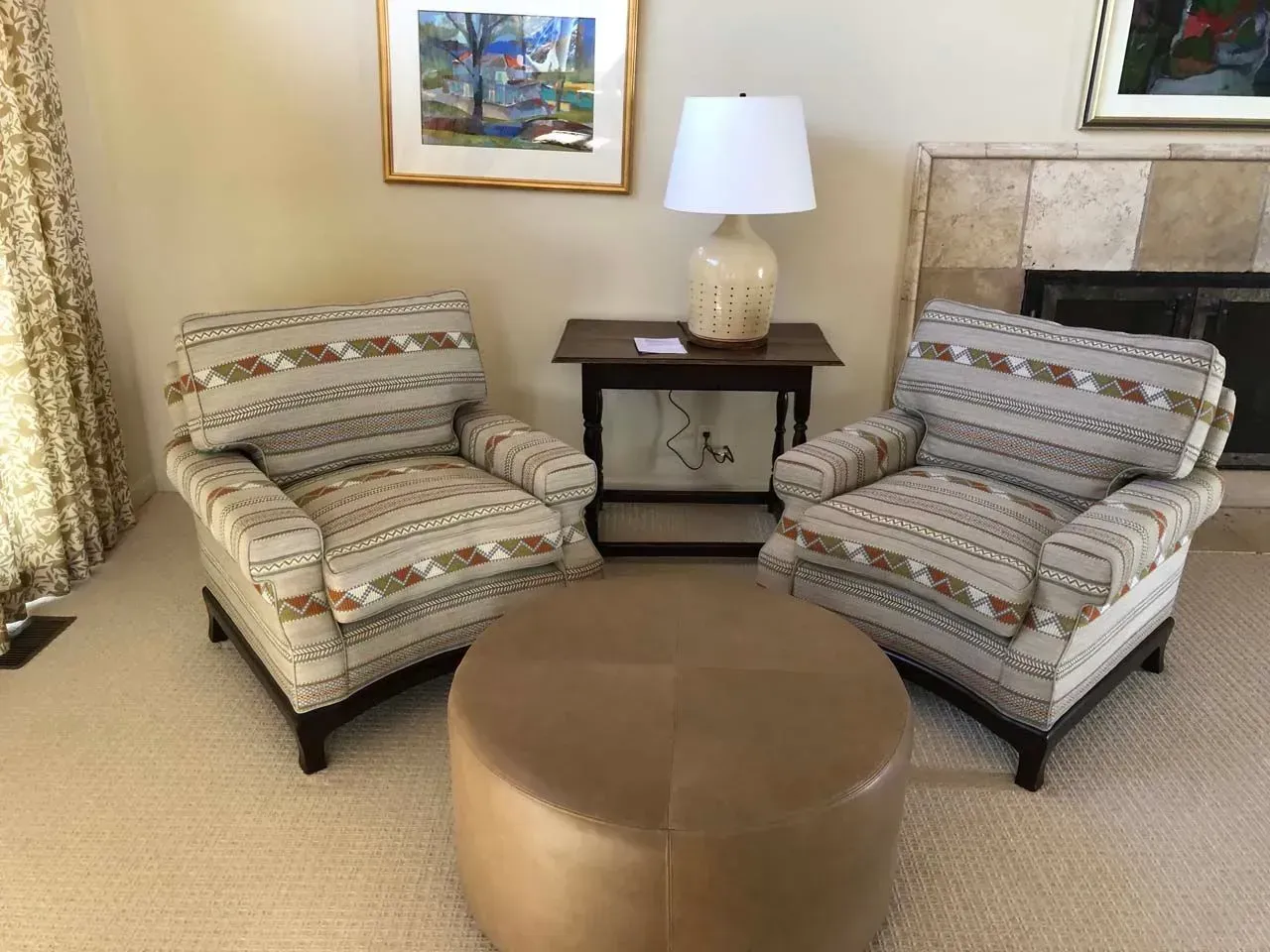 A living room with two chairs and an ottoman