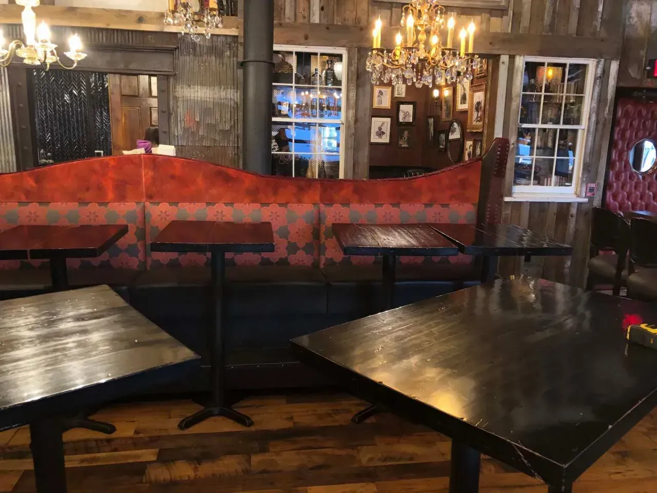 A restaurant with tables , a couch , and a chandelier.