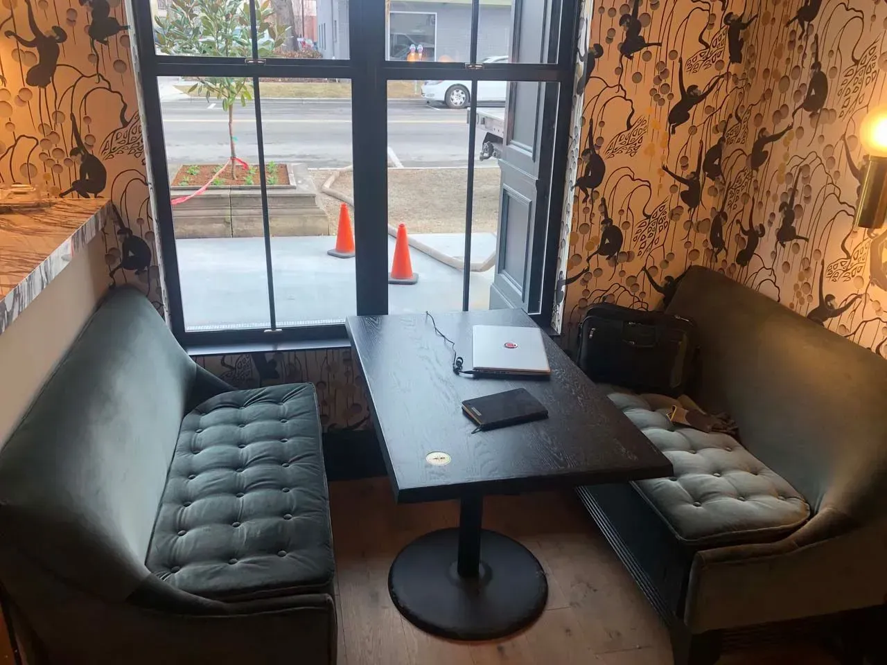 A small room with a table and a couch in front of a window.