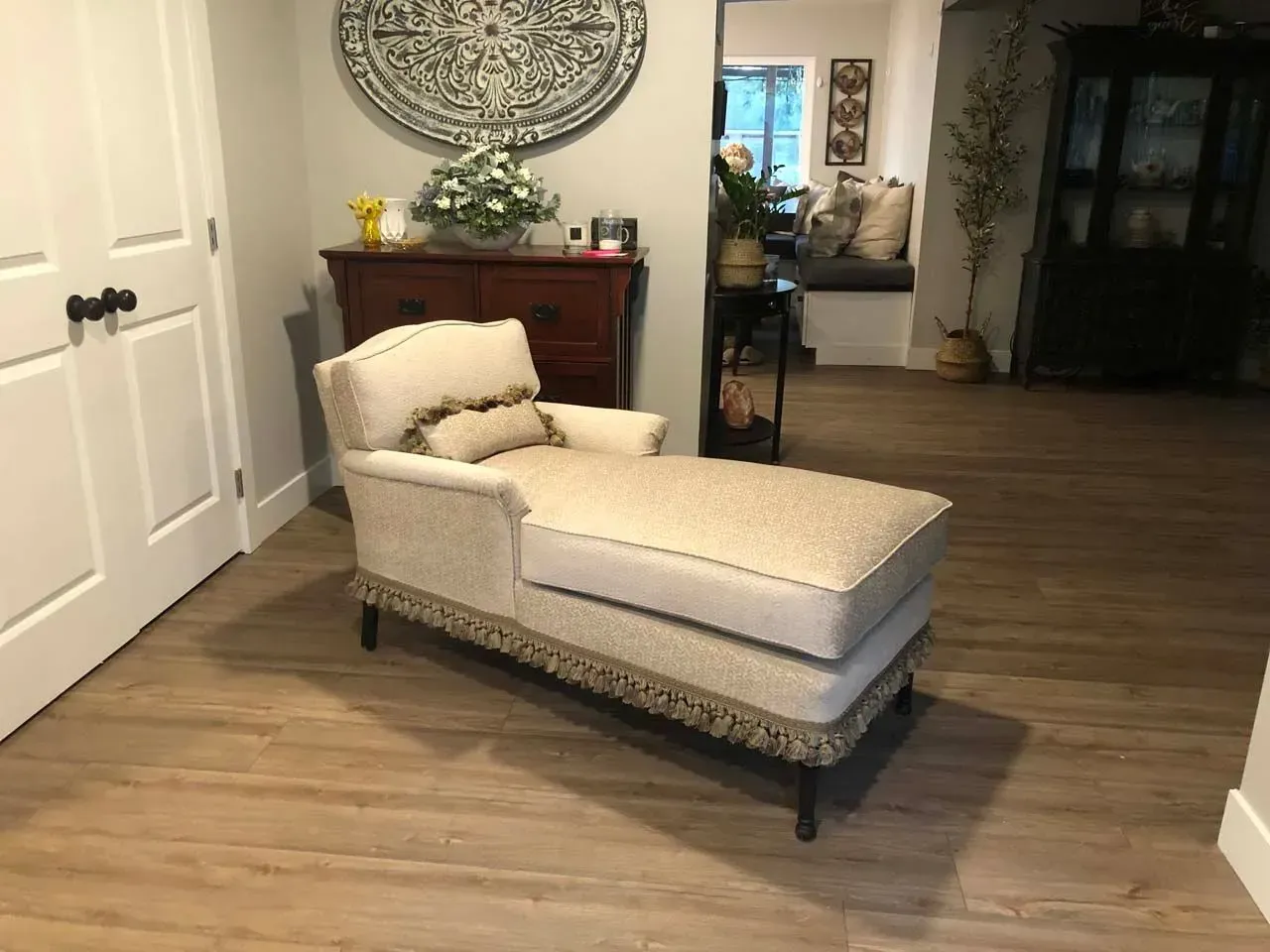 A chaise lounge is sitting in a living room next to a dresser.