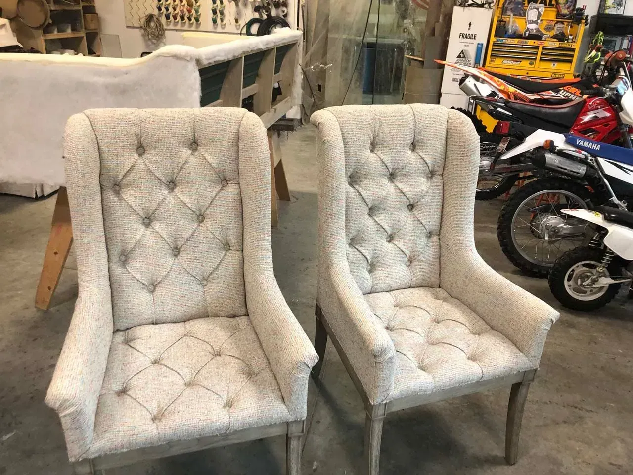 Two white chairs are sitting next to each other in a room.