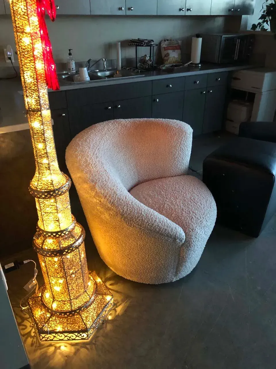 A chair in a living room next to a lamp