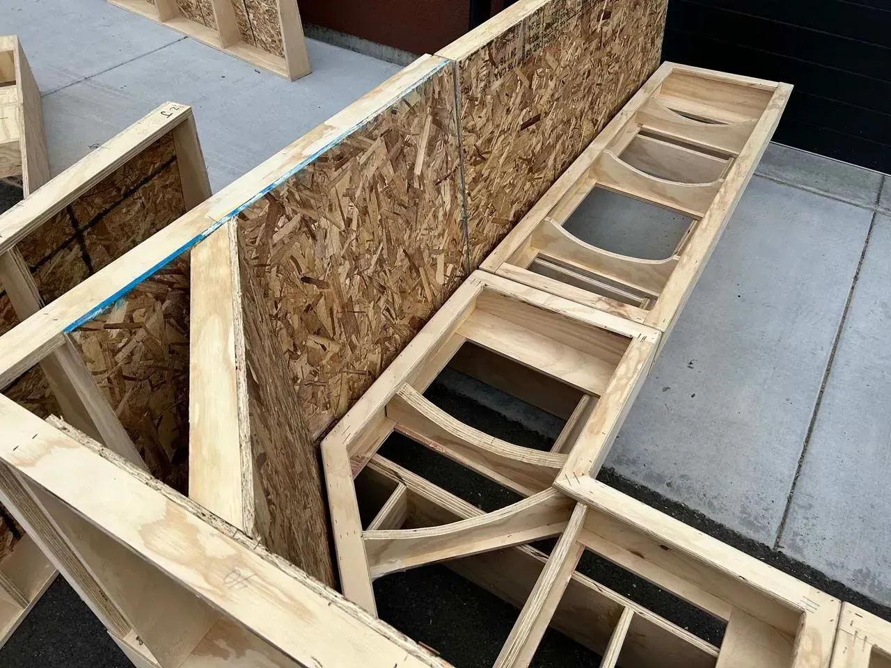 A bunch of wooden boxes are sitting on a sidewalk.