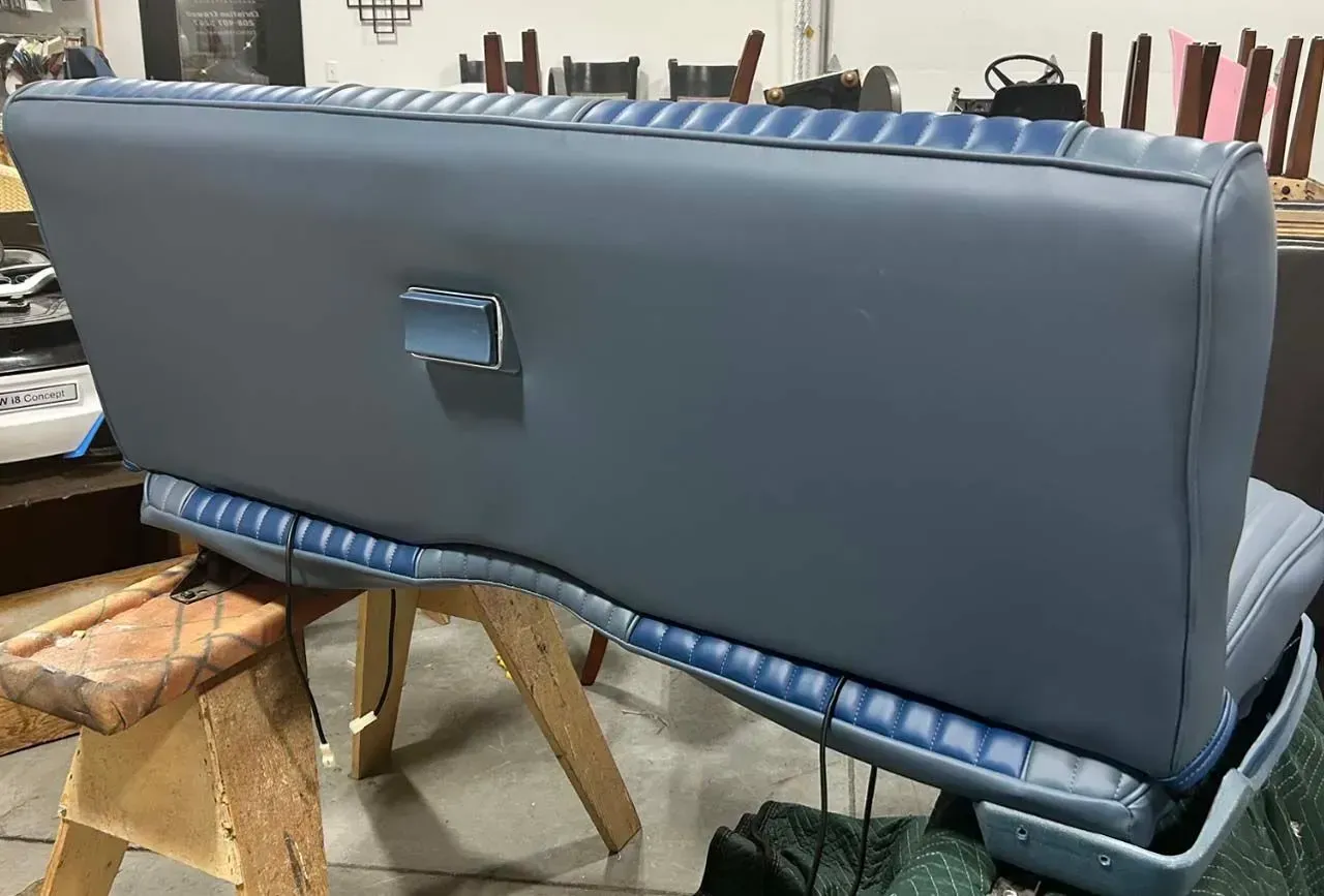 A blue couch is sitting on top of a wooden table.