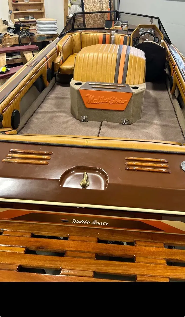 The inside of a boat with a wooden deck and a couch.