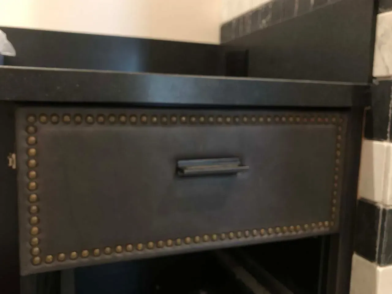 A black cabinet with a drawer underneath it.
