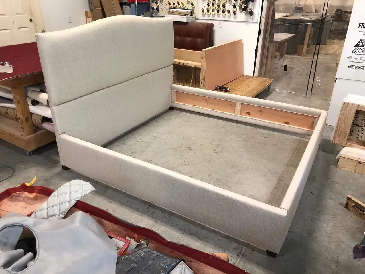 A bed frame is sitting on the floor in a room.