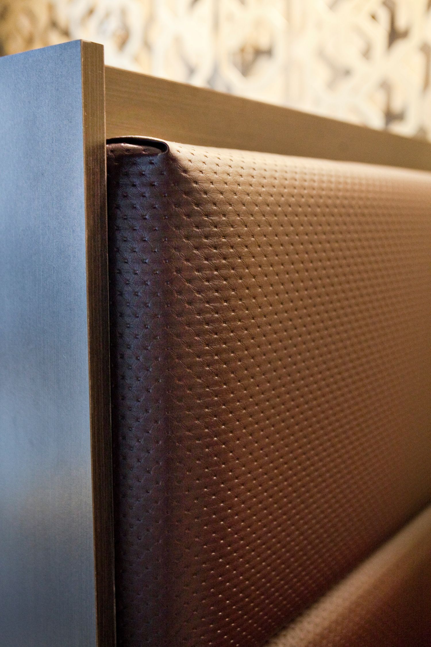 A close up of a brown leather couch with a metal frame.