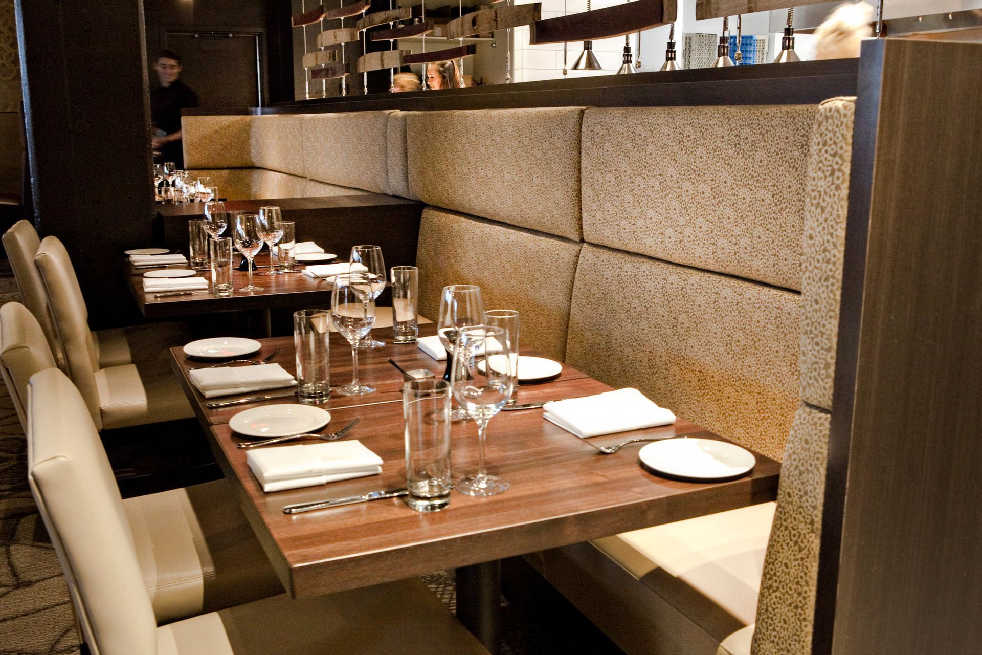 A row of tables in a restaurant with wine glasses on them