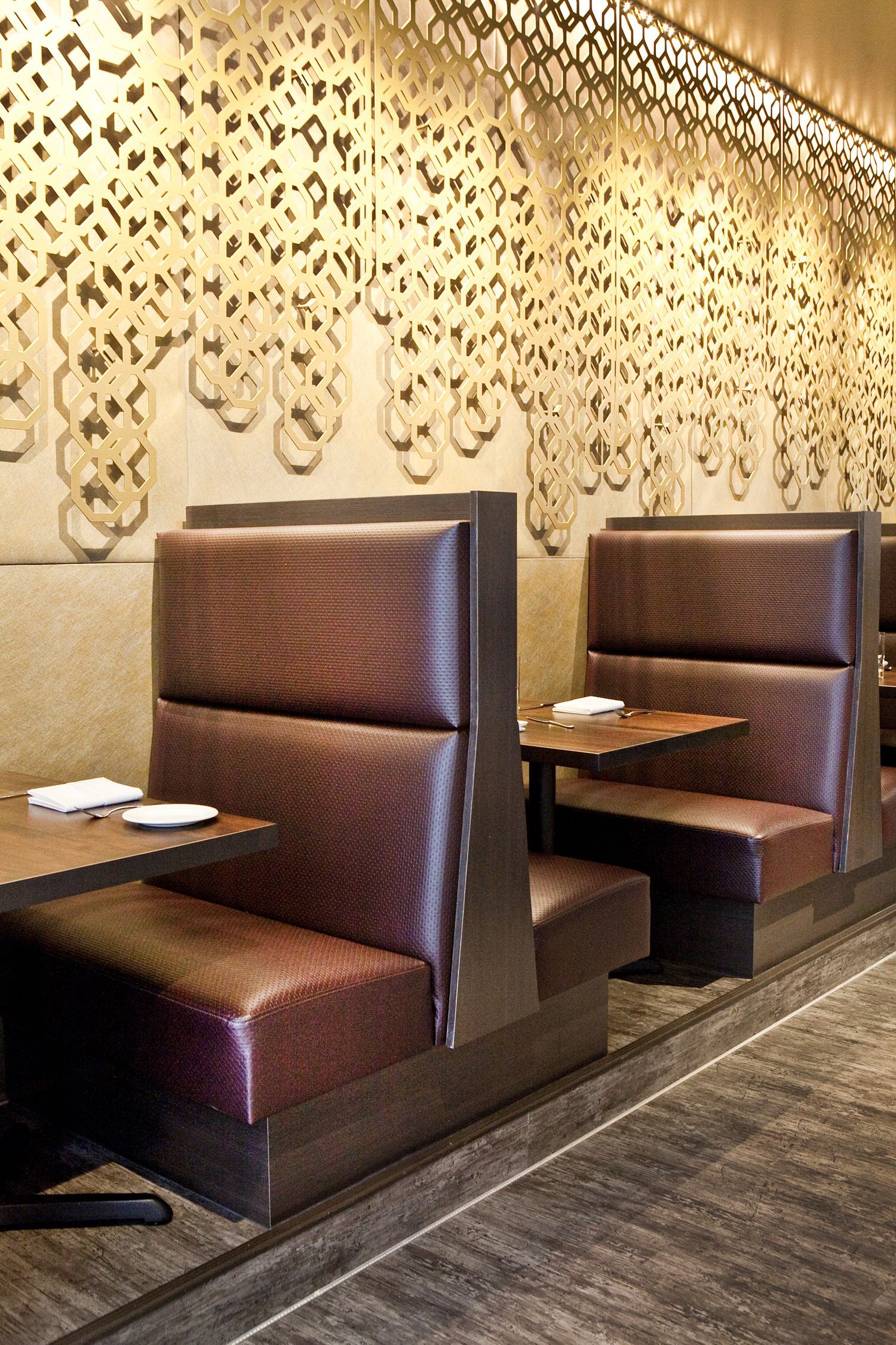 A row of booths in a restaurant with tables and plates on them.