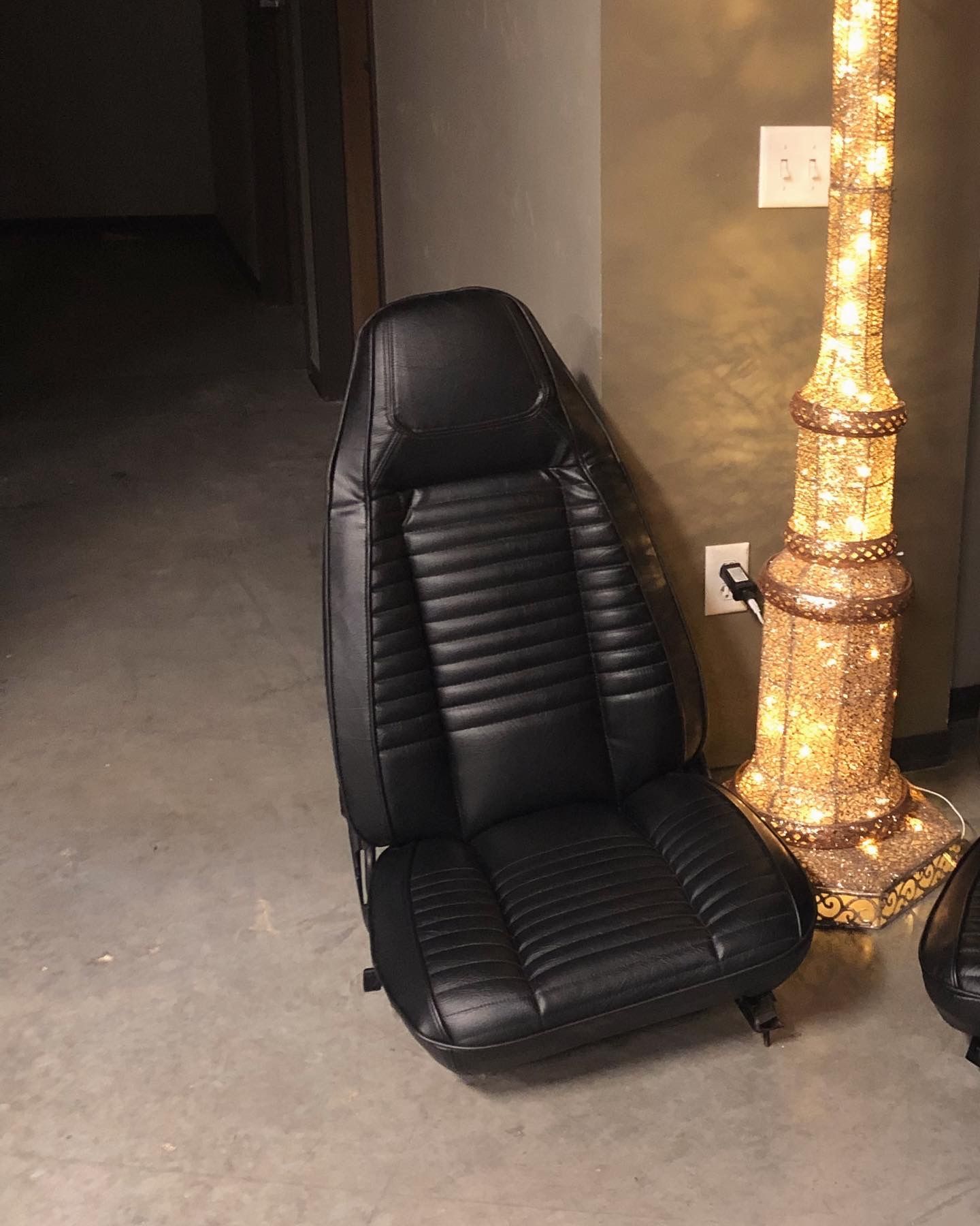 A black leather chair is sitting next to a lamp