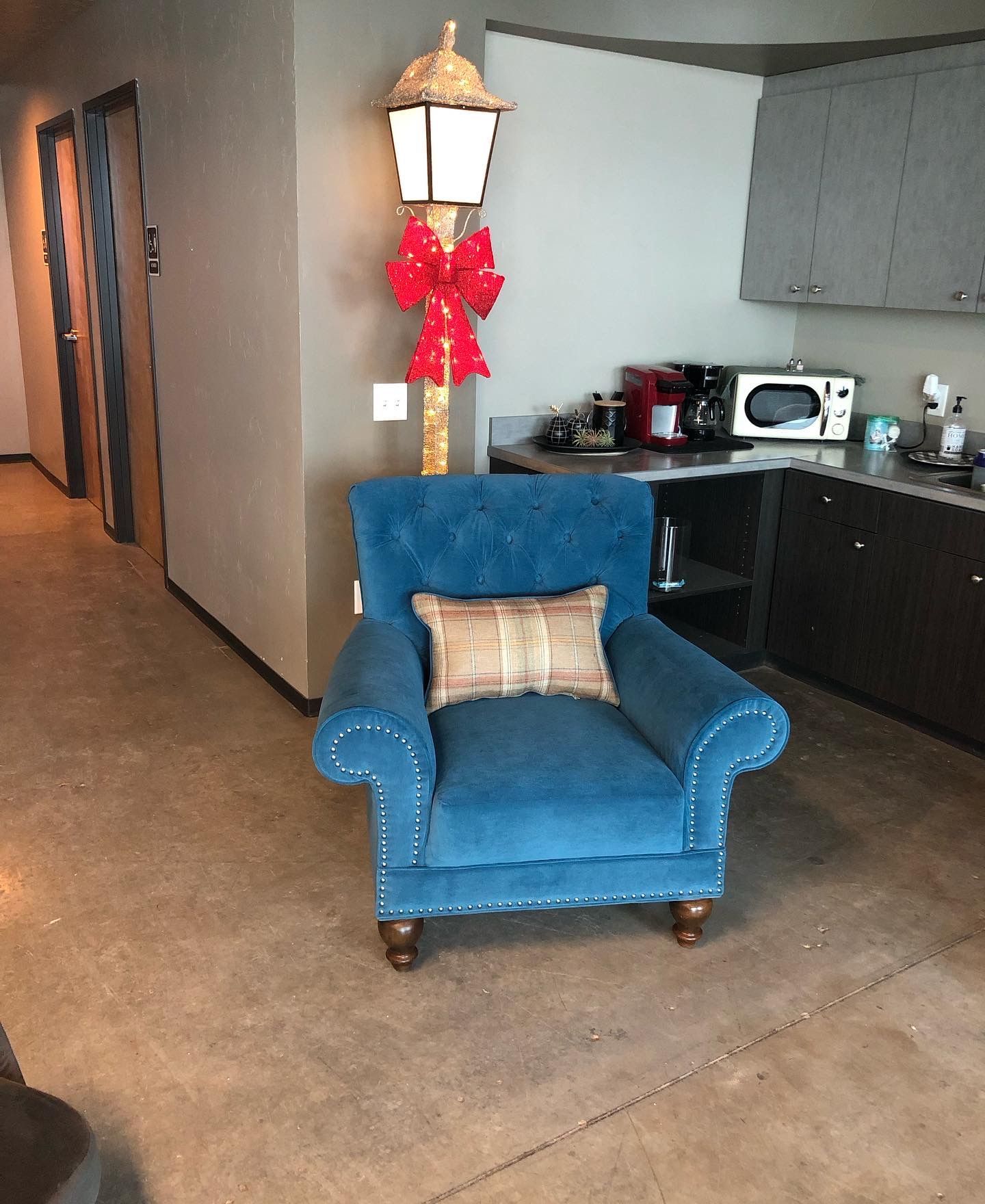 A blue chair in a kitchen next to a lamp post
