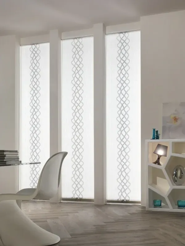 Stanza moderna bianca con alte finestre satinate, una sedia bianca e una piccola mensola con oggetti decorativi.