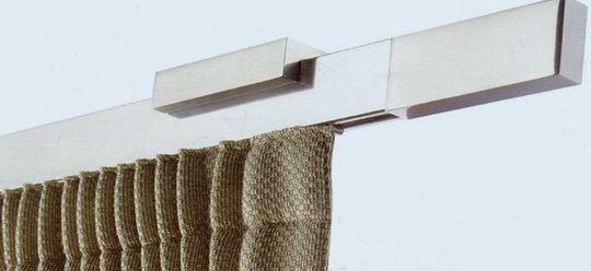 Supporto per asta per tende montato a parete sopra una tenda beige