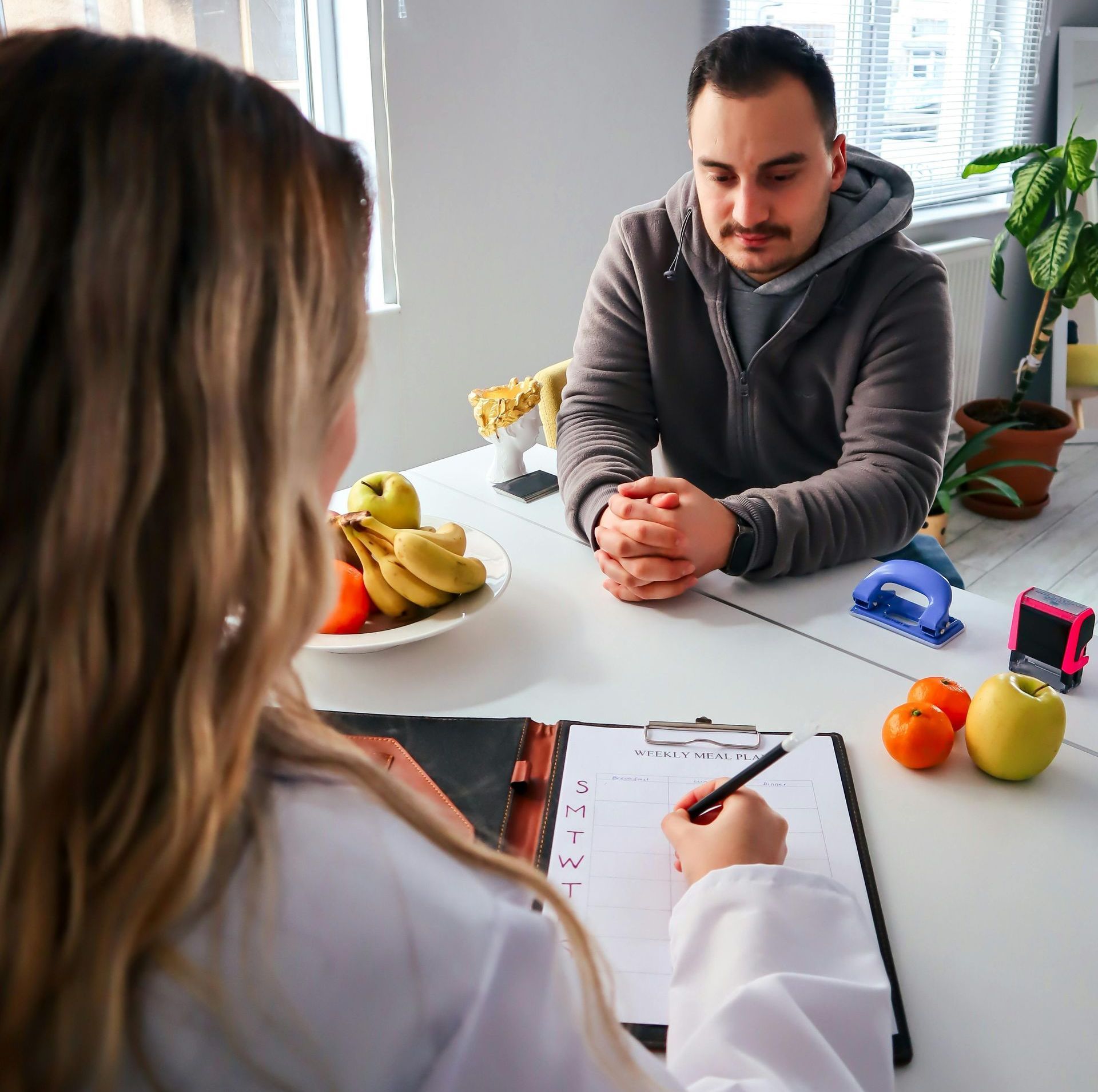 A woman is sitting at a table talking to a man.