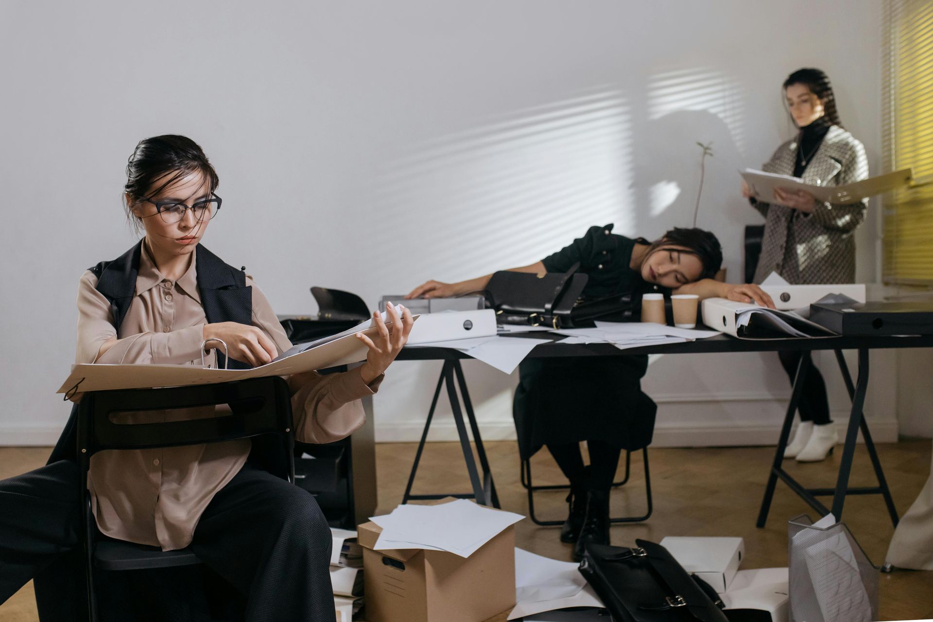 A group of women are sitting at desks in an office.