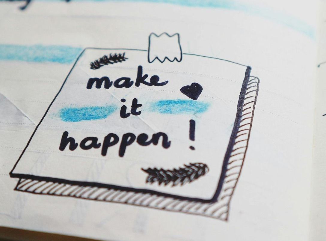 A book is open to a page that says make it happen