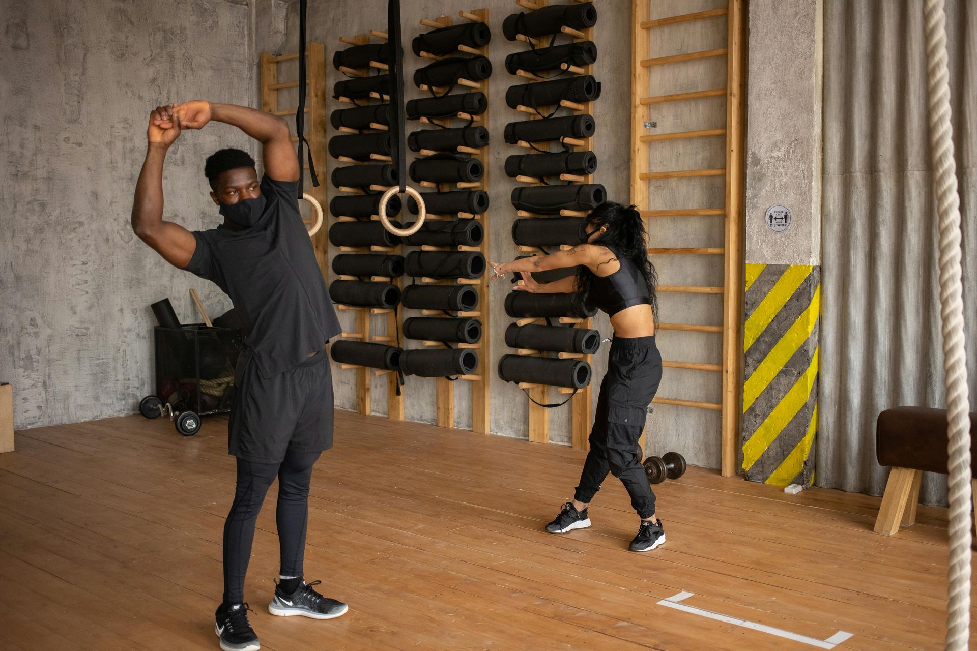 A man and a woman are doing exercises in a gym.