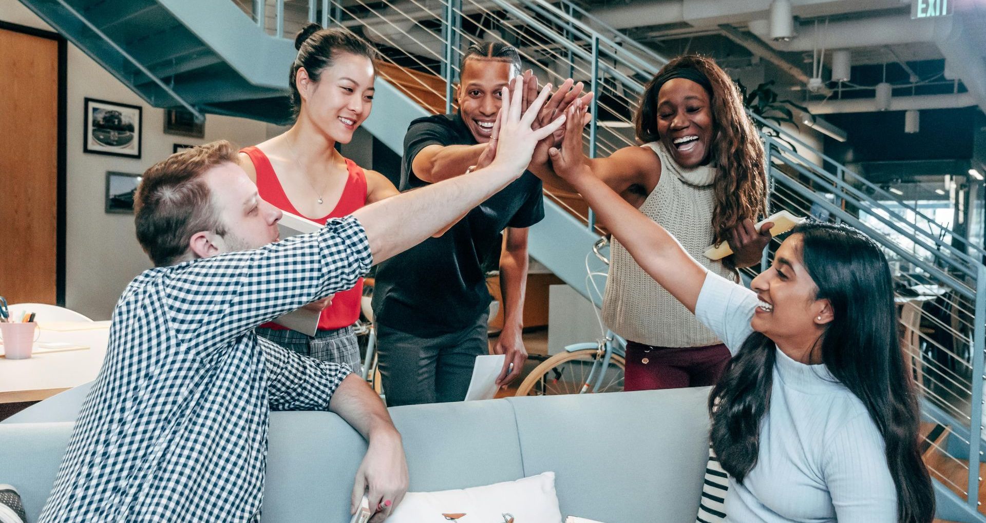 A group of employees are giving each other a high five.