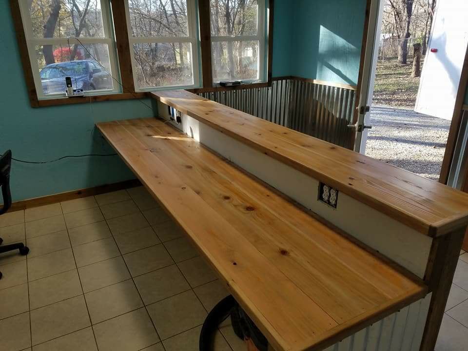 A long wooden counter in a room next to a window