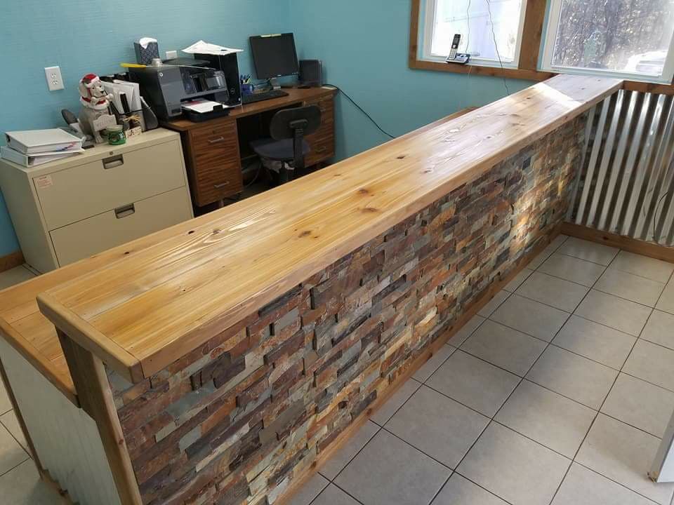 A long wooden counter in a room with a brick wall