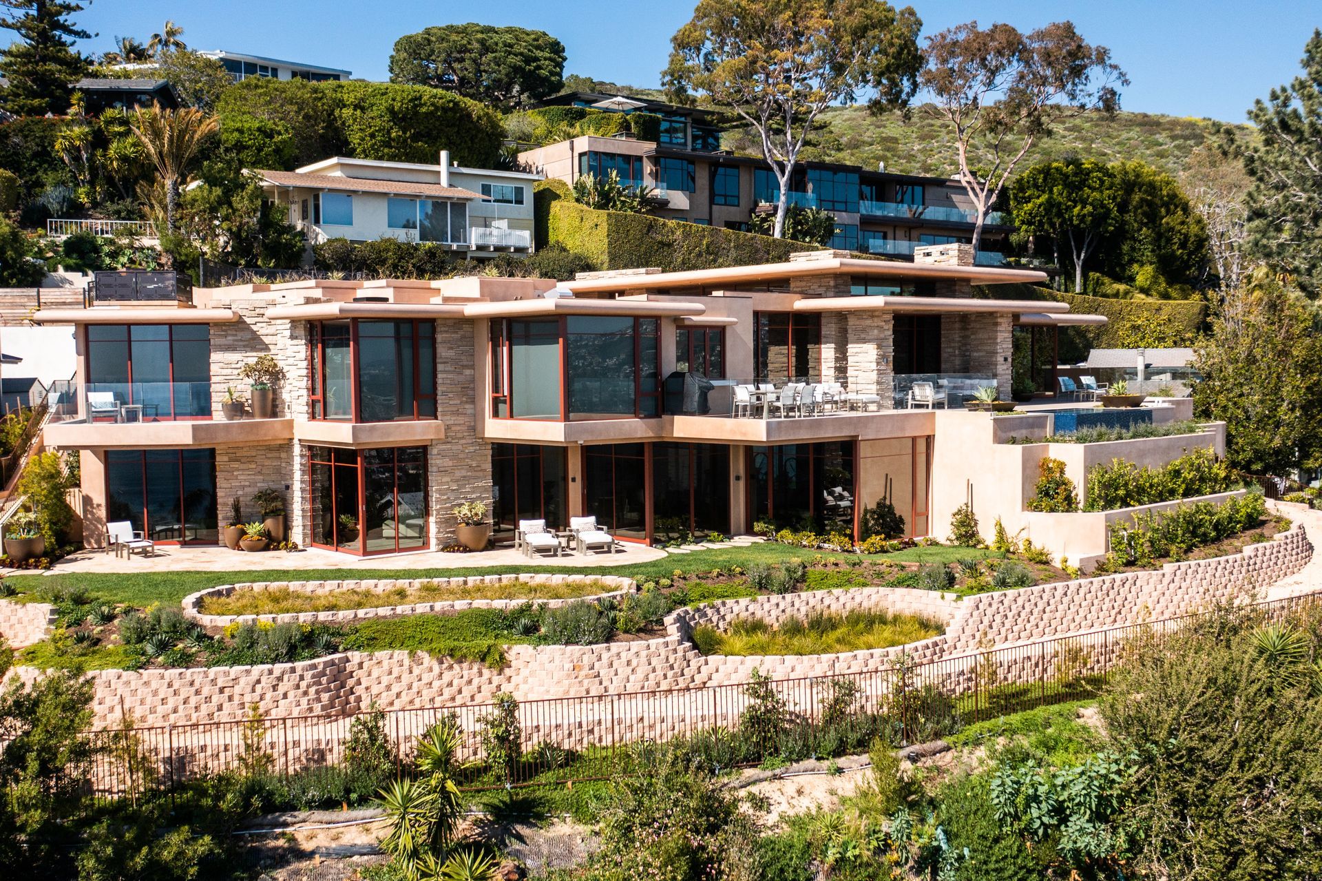 a large house sits on top of a lush green hillside