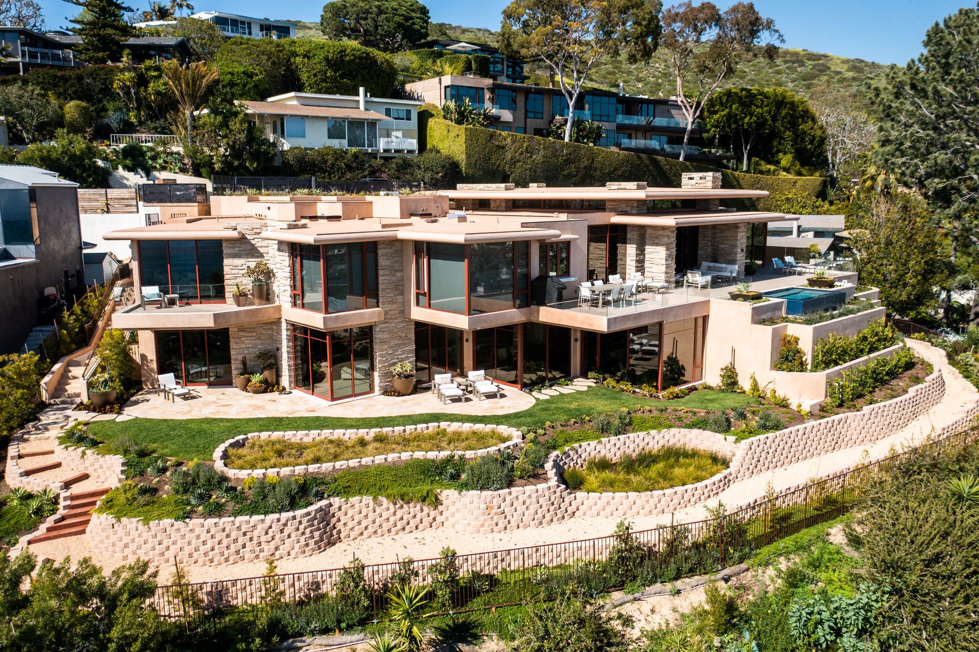a large house sits on top of a lush green hillside