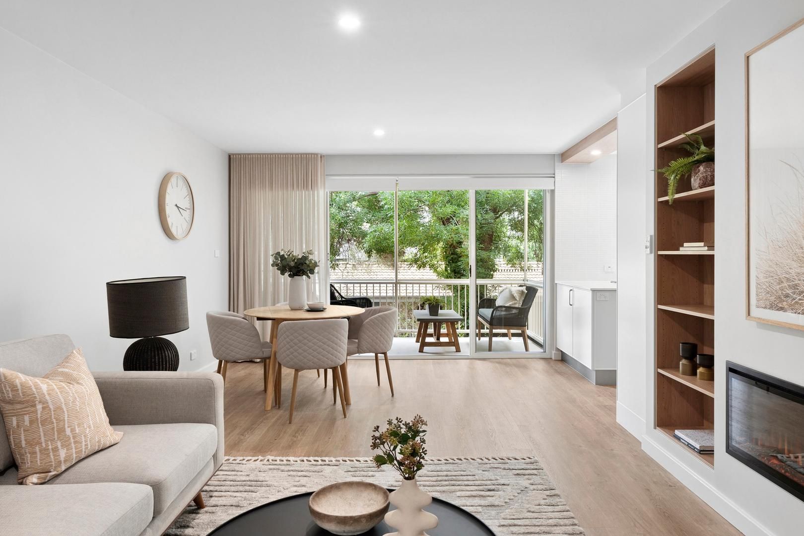 A living room with a couch , table , chairs and a fireplace.