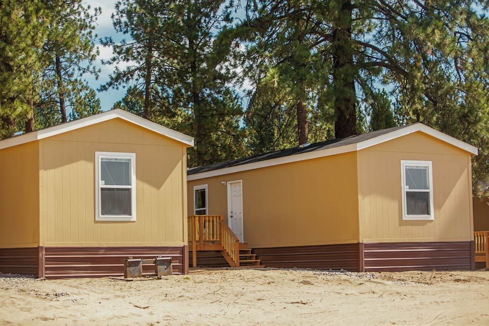 Two Mobile Homes Are Sitting Next To Each Other On A Dirt Field — Professional Painters in Kingscliff, NSW