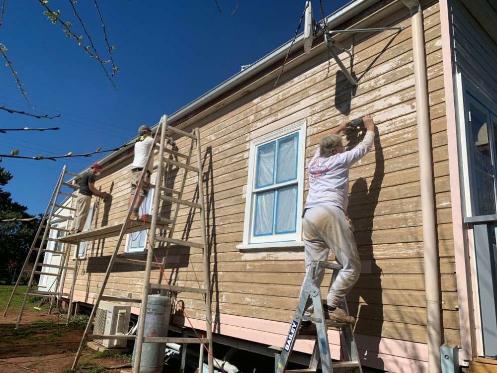 A Group of People Are Painting the Side of a House — Professional Painters in Suffolk Park, NSW