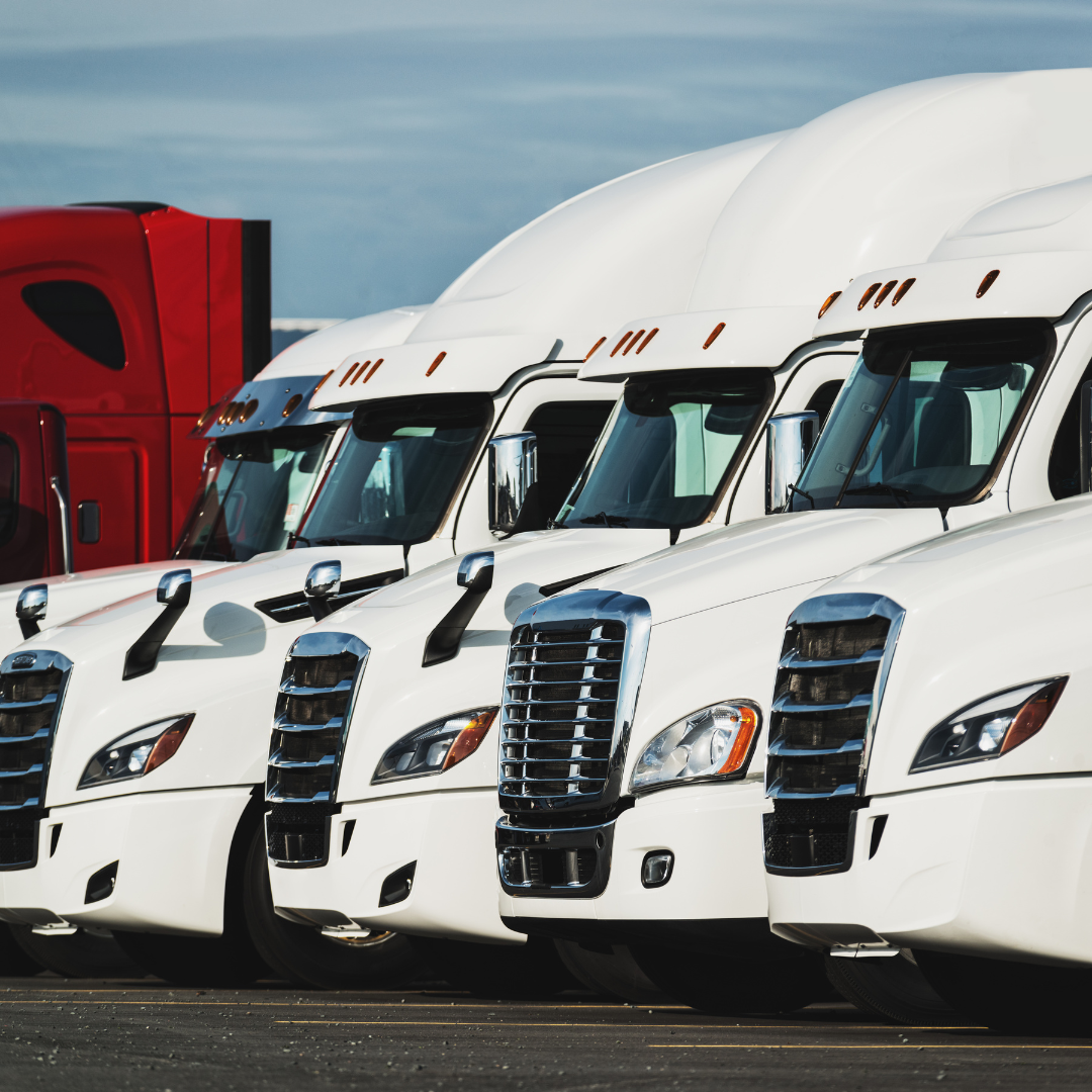 A row of semi trucks are parked next to each other