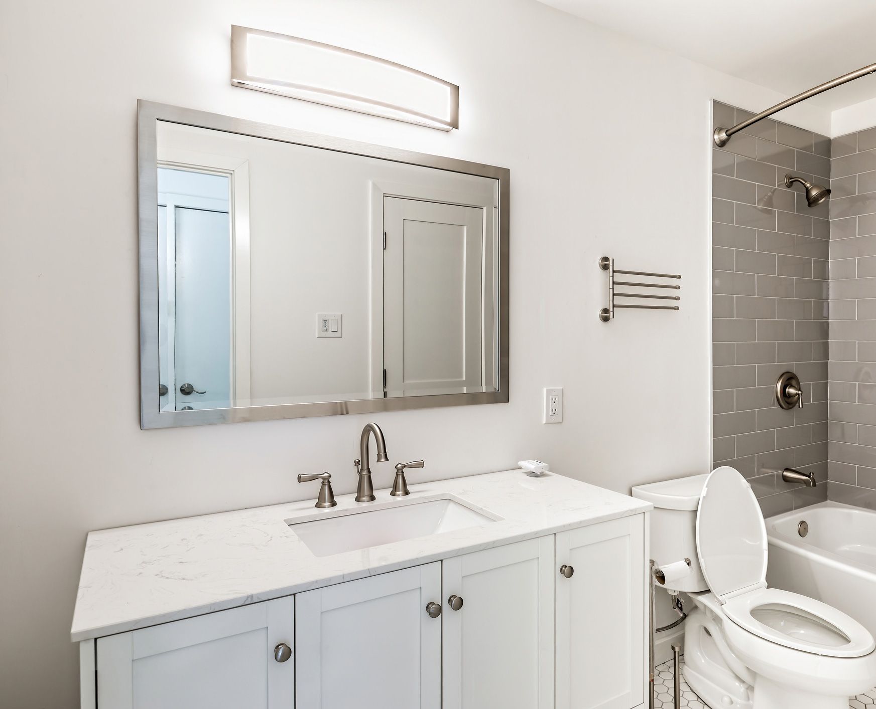A bathroom with a toilet , sink and mirror